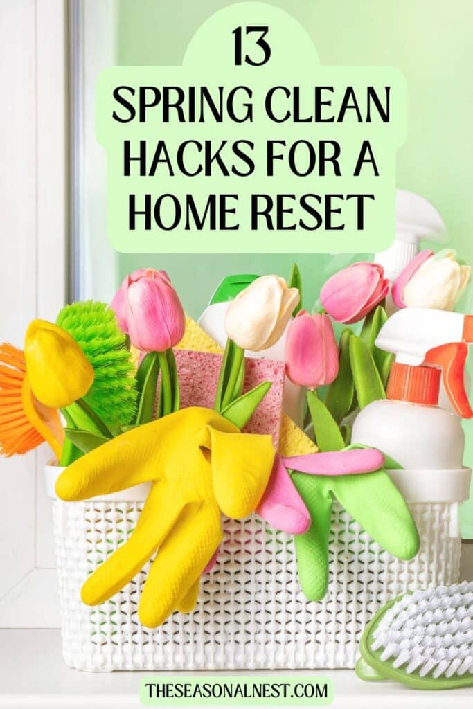 Spring cleaning supplies in a white basket with yellow and green rubber gloves, cleaning spray bottles, sponges, and pink tulips, with text overlay “13 Spring Clean Hacks for a Home Reset."