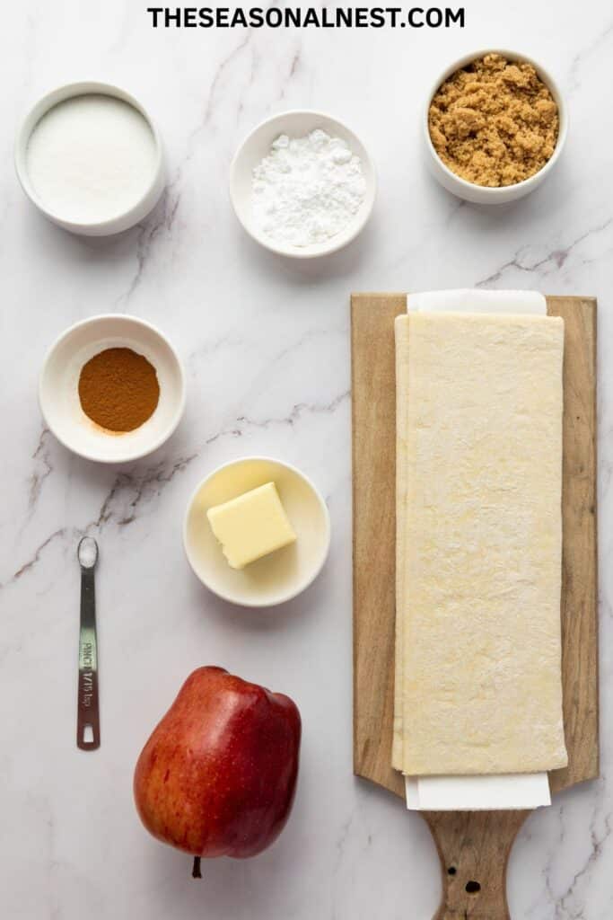 Ingredients for upside-down apple tarts including puff pastry, butter, apples, cinnamon, and sugar.