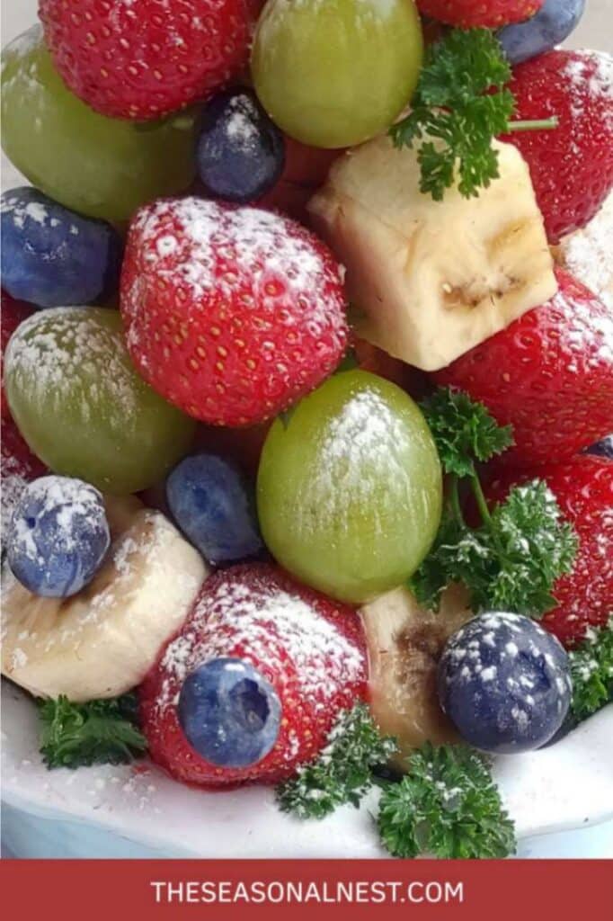 Close up of fruits with snowy sugar arranged in a shaped tree.