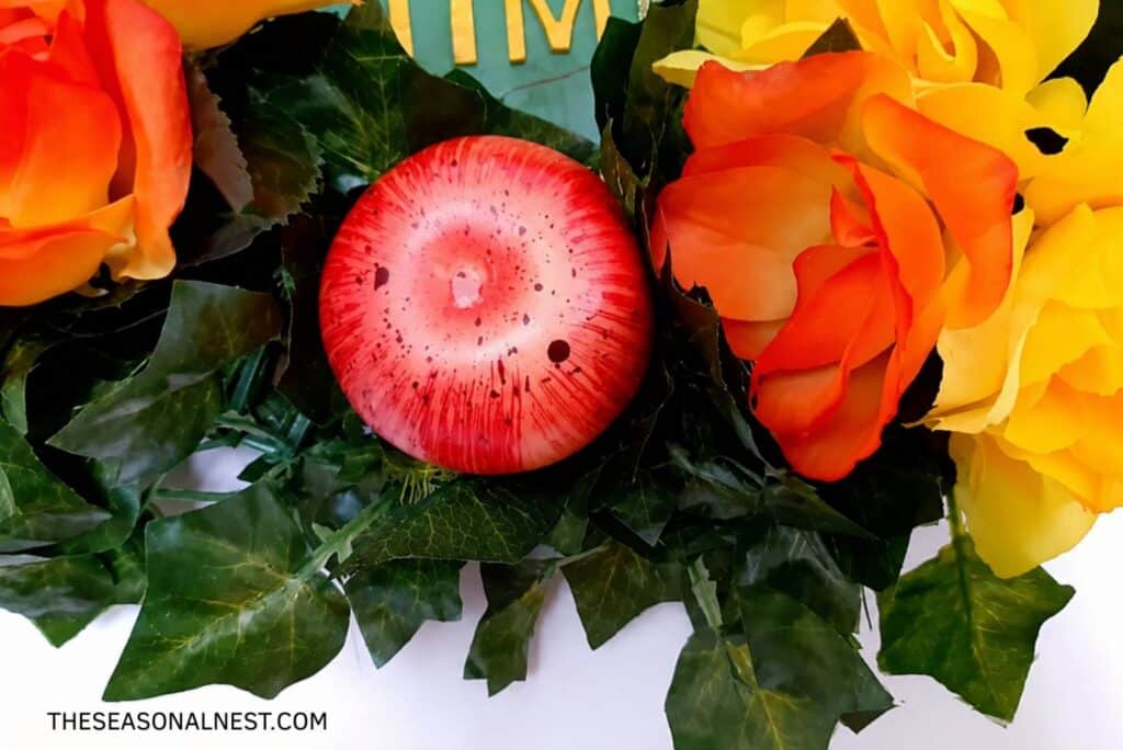 Attaching ornamentslike an apple to the wreath