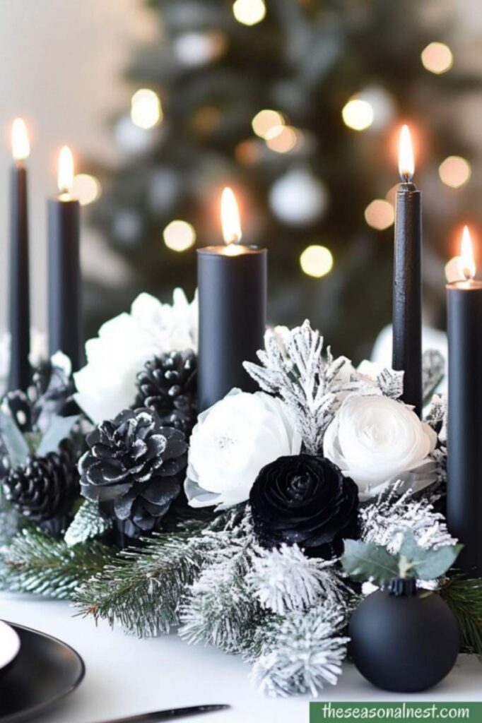 Elegant black and white Christmas table centerpiece with candles, frosted pinecones, and white flowers.