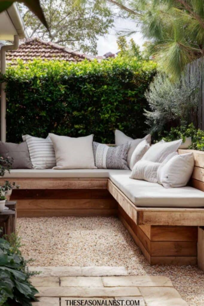 Built-in corner bench with cushions in a small backyard patio.