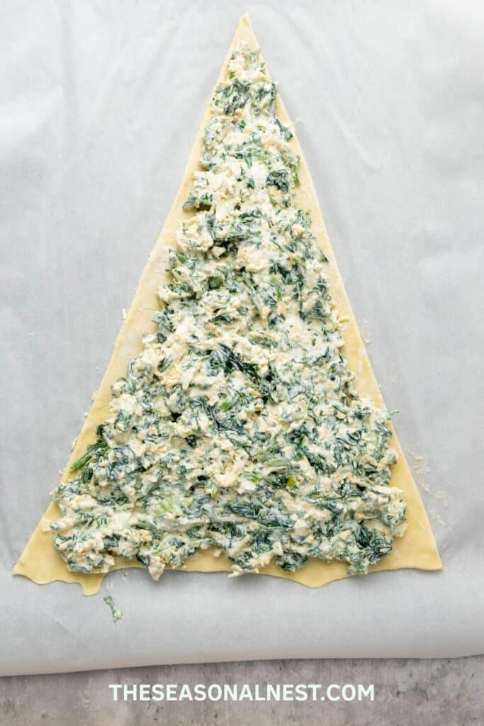 Puff pastry sheet shaped like a Christmas tree and filled with spinach dip.