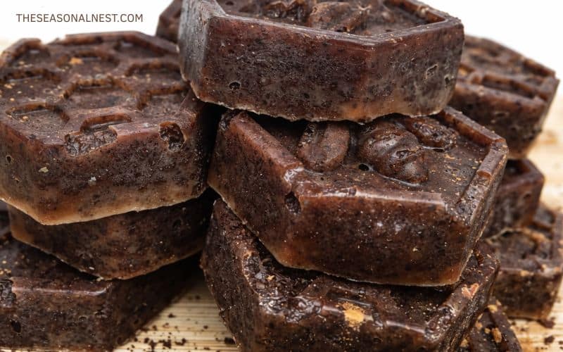Close up of stacked DIY coffee scrub bars in the form of hexagons with honeycomb and coffee bean details.