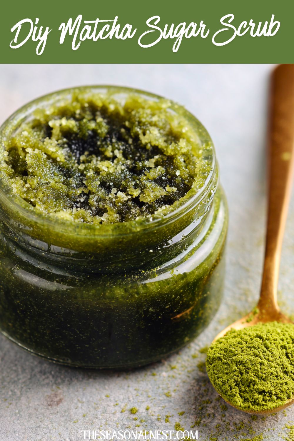 DIY Matcha body scrub in a glass jar with a spoon full of matcha powder.