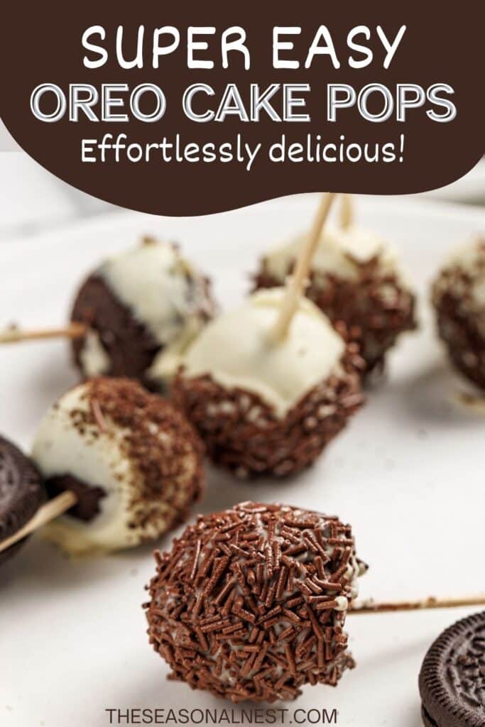 Chocolate-sprinkled Oreo cake pops on sticks with white chocolate drizzle, displayed on a plate.