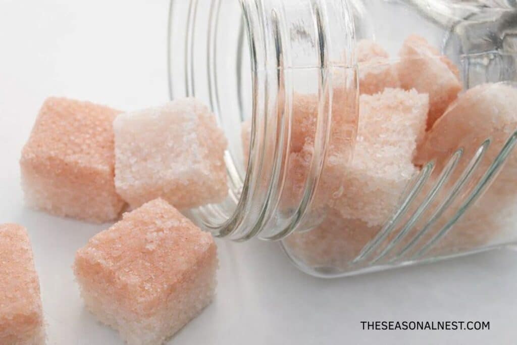 DIY sugar scrub cubes with Himalayan salts in an open jar.