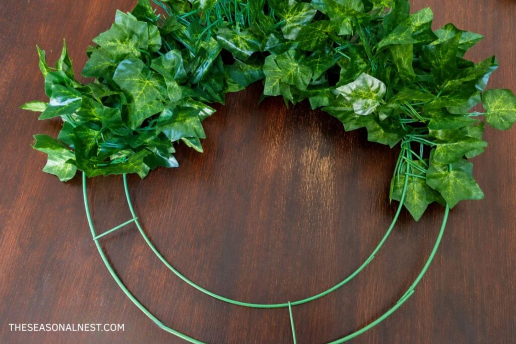 Greenery around a metal hoop with green wire