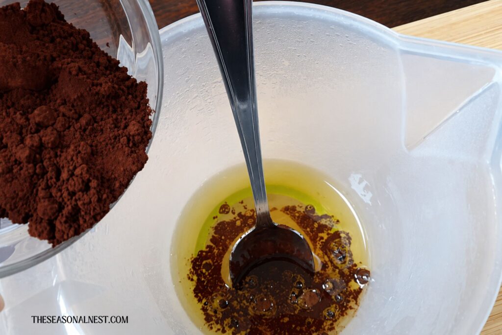 Mixing cacao and oil to make chocolate lotion bars.