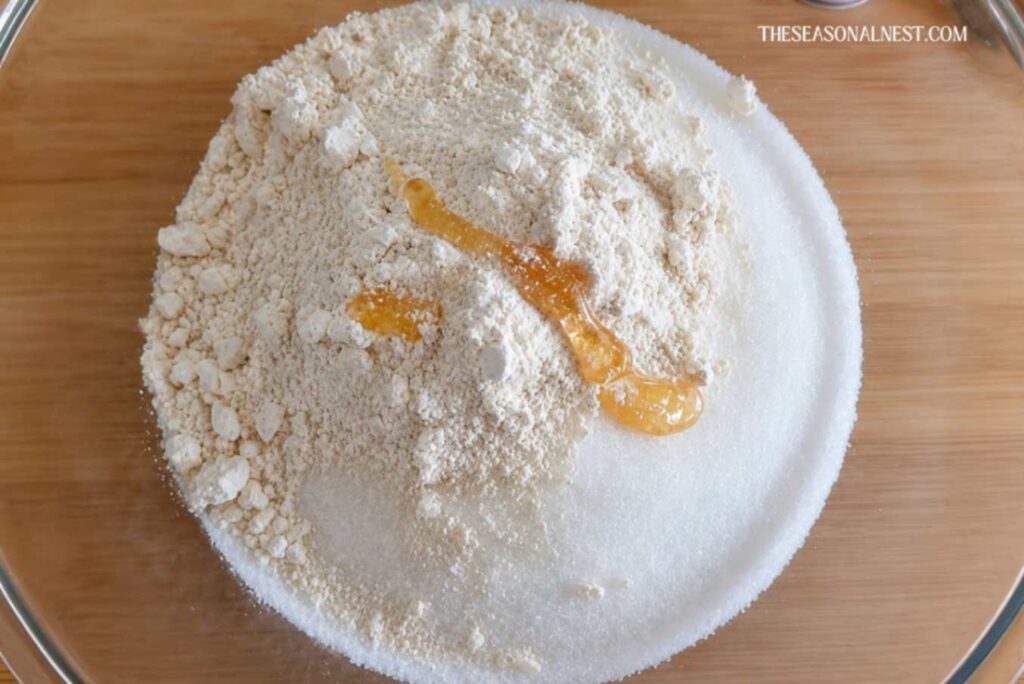 Sugar, oats, and honey in a bowl.