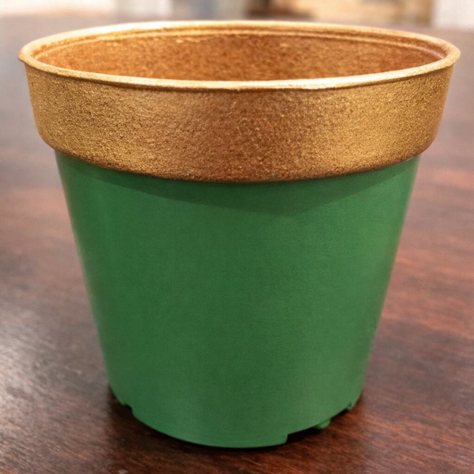 A plastic plant pot painted in green with a golden rim