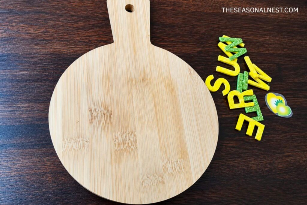 A wooden board and small assorted glitter letters
