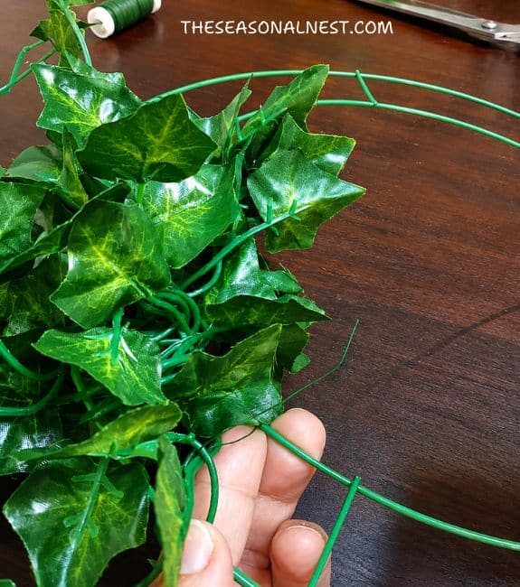 Attaching greenery around a metal hoop